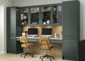 Bespoke Heritage Green office with fitted cabinetry, double workstation, glazed display cabinets, integrated storage and oak slatted feature panelling.