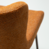 glam-swivel-chair-pumpkin-spice-boucle-w-antique-brass-legs_100208304-06-detail A close up image of the detail of the Glam swivel chair in pumpkin spice with black metal legs.