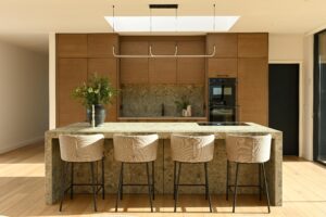 A striking blend of rich wood tones, textured stone, and sleek modern finishes – this kitchen is a statement of refined luxury and functionality.