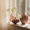 A set of 3 Amalie Vase in fawn colour on a window cill.