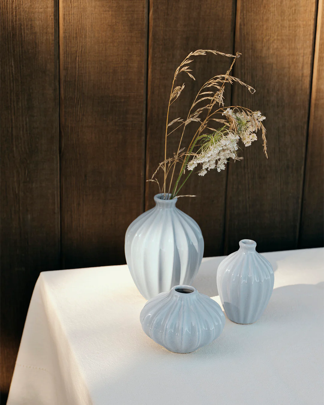 A set of 3 amalie vase in light blue on a table