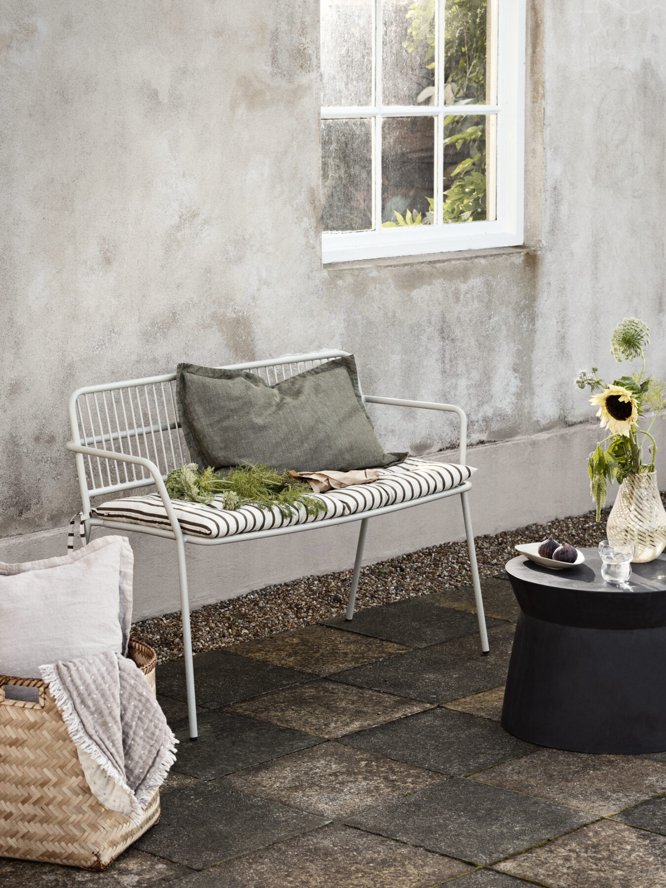 Eden bench in beige grey outside in a pation wityh a cushion
