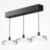 Float triple pendant light with clear glass shades and black frame over kitchen island
