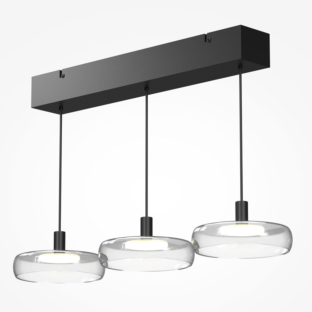 Float triple pendant light with clear glass shades and black frame over kitchen island