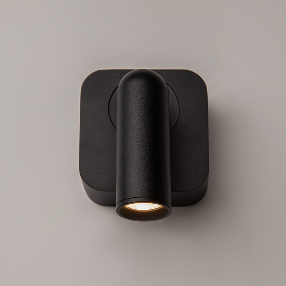 black adjustable wall reading light with focused spotlight, modern bedside wall light