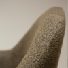 Close up of the dark olive boucle fabric on the BAE Armchair with antiquepewter swivel legs