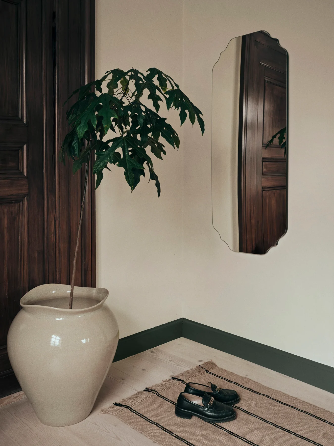 The Florentina Beige Floor Vase XL with a plant on a timber floor