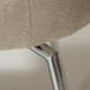 glam-chair-swivel-simply-beige-boucle-w-chrome-swivel-legs_100208323-06-detail1 Close up of the detail of the glam chair swivel in simply beige boucle fabric with chrome legs.