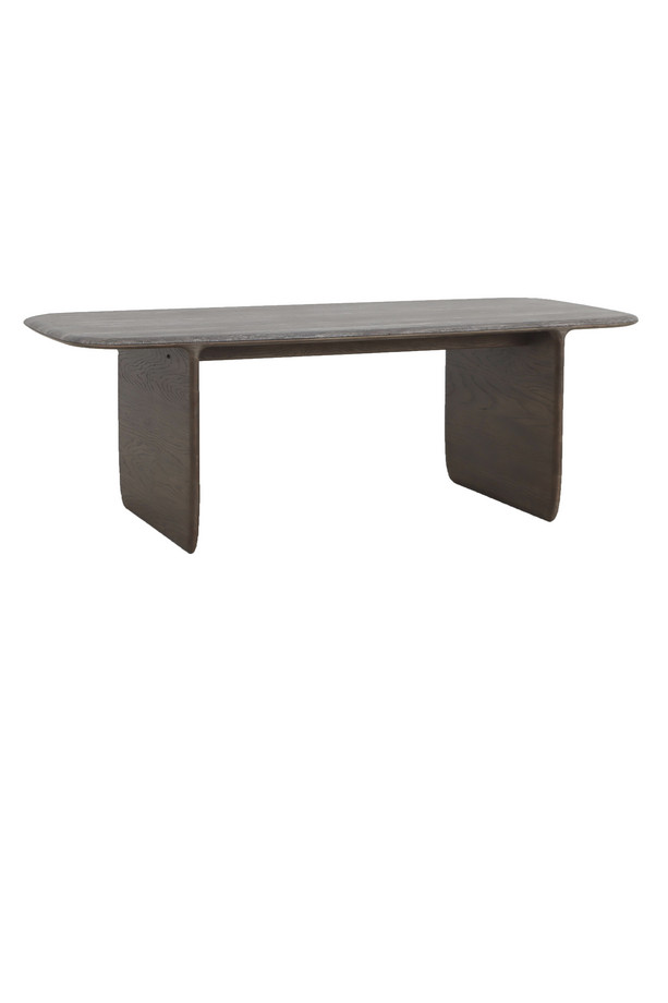 Howitt walnut oak rectangular dining table with bold panel legs, softened edges, and visible wood grain detail on a white background.