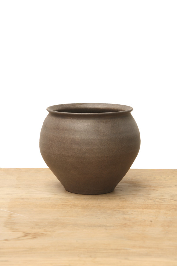 Medium brown ceramic vase with a rounded shape, flared rim, and earthy finish on a wooden surface.