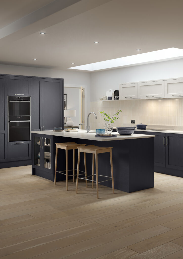 Navy shaker kitchen with large island, light grey wall cabinets and stone worktops.