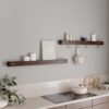 Protopia wall shelf in walnut veneer with a slim profile and curved ends, ideal for displaying artwork, books, photographs, and decorative accessories.