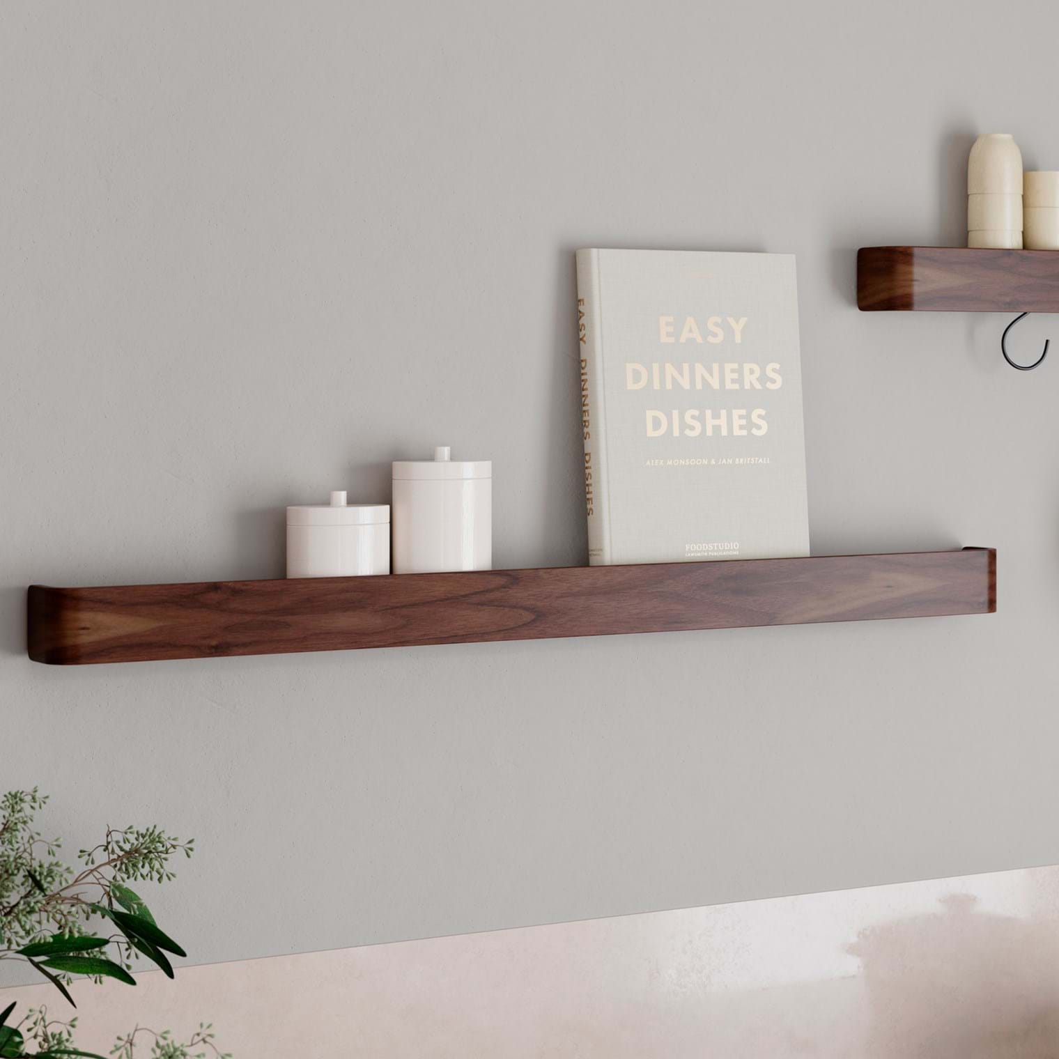 Protopia wall shelf in walnut veneer with a slim profile and curved ends, ideal for displaying artwork, books, photographs, and decorative accessories.