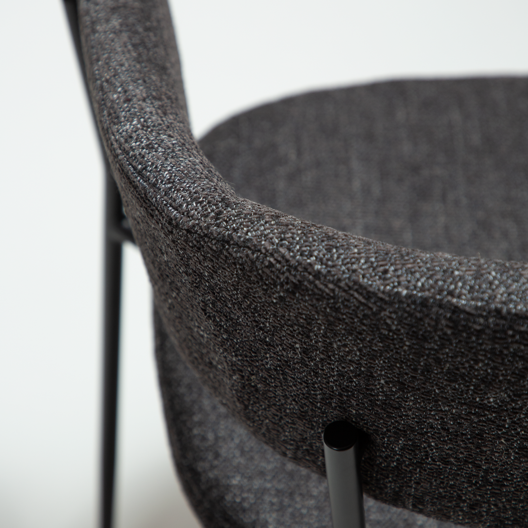 reboot-armchair-raven-black-close Reboot armchair upholstered in Raven Black fabric with a modern curved silhouette and upholstered frame.