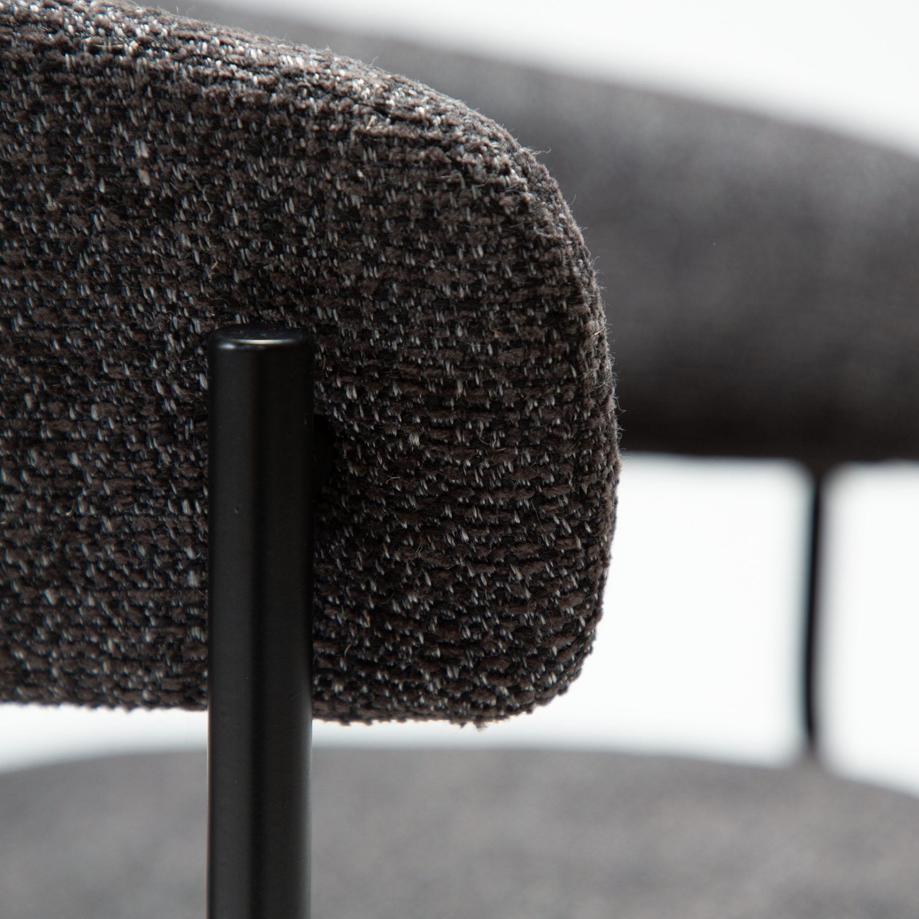 reboot-armchair-raven-black-handle Reboot armchair upholstered in Raven Black fabric with a modern curved silhouette and upholstered frame.