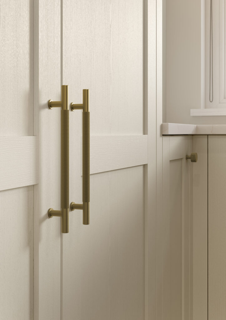 Close-up of taupe shaker kitchen cabinetry with brushed brass handles and textured woodgrain finish.