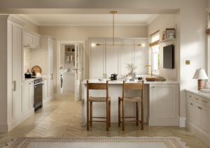 Taupe shaker kitchen with island seating, brass handles and integrated utility room.