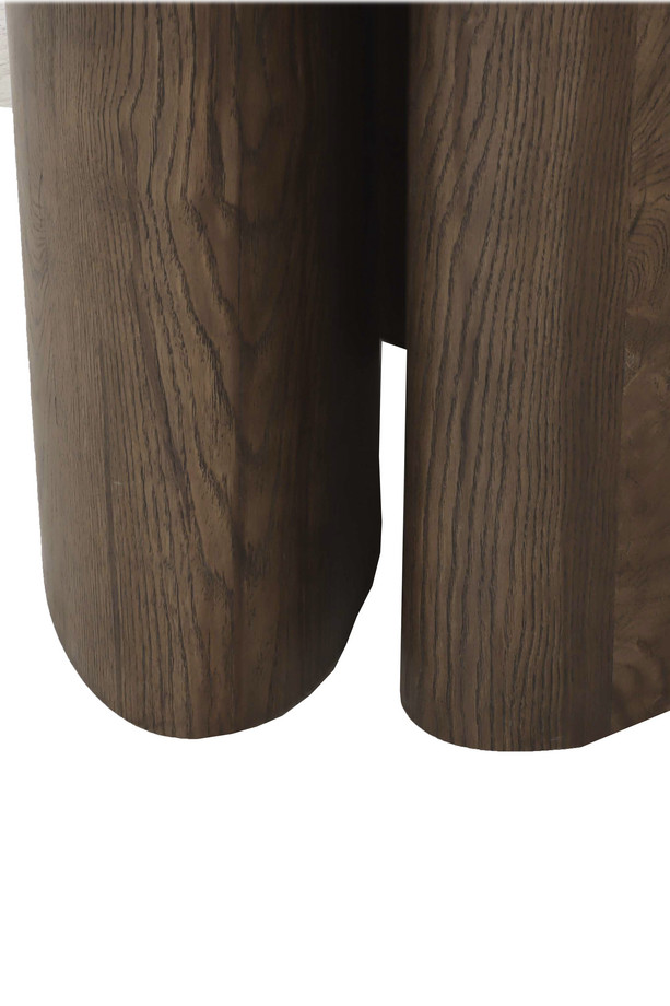 Walnut oak oval dining table with a warm wood finish, rounded tabletop, and sculptural pedestal base on a white background.