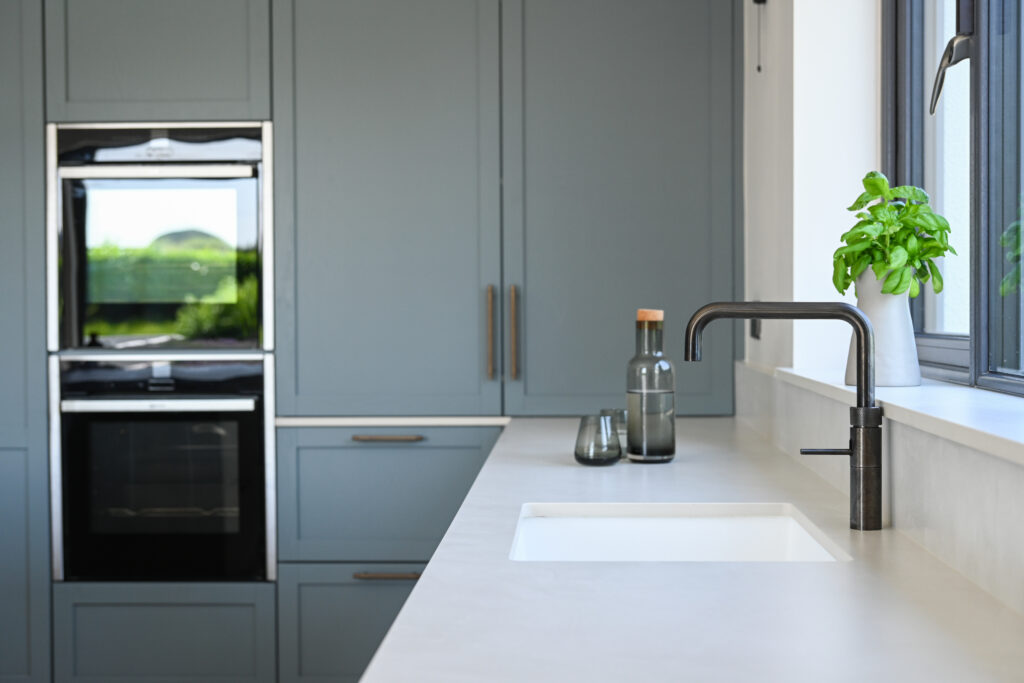 French Denim Shaker kitchen with integrated ovens, Dekton Albarium worktop, undermount sink and Quooker tap.