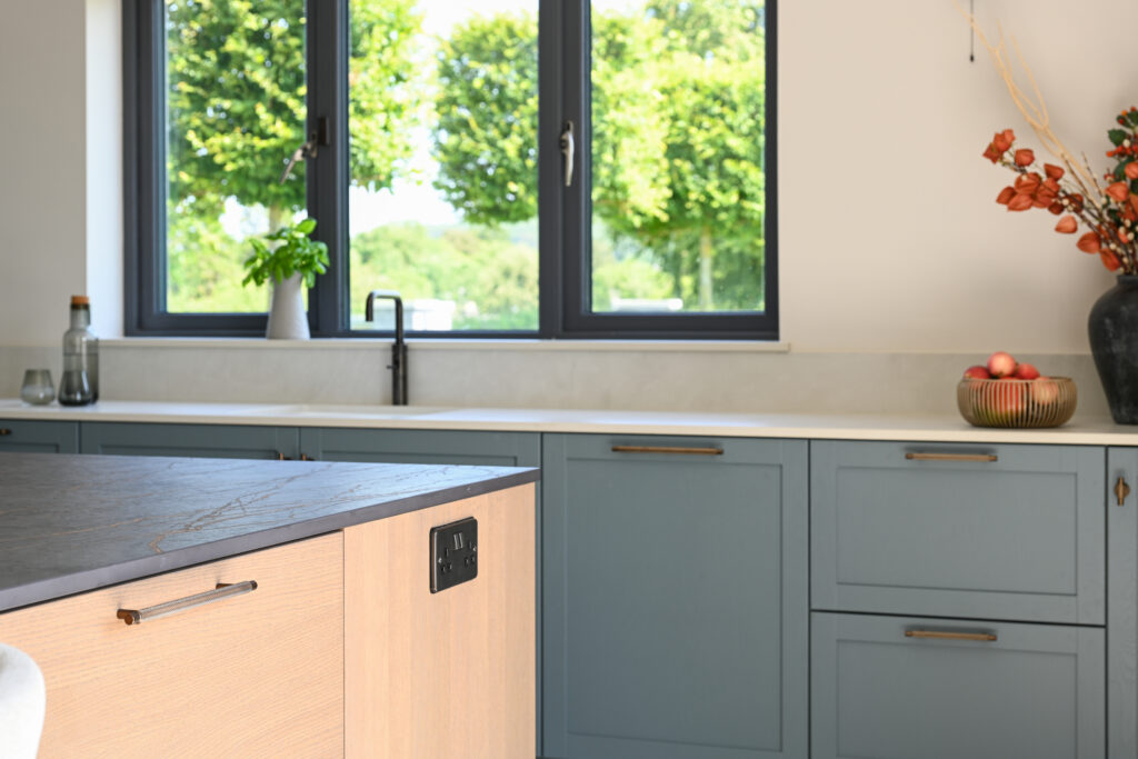Bespoke timber kitchen island with Dekton Laurent worktop in a French blue Shaker kitchen