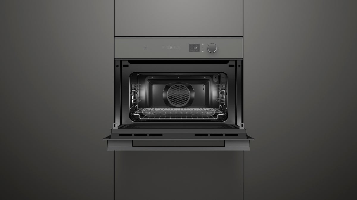 fisher-paykel-minimal-compact-combi-microwave-oven-grey-unit-open Fisher & Paykel Minimal grey compact combi microwave oven with 19 cooking functions, Wi-Fi connectivity, and touchscreen controls.