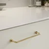 Lounge untreated polished brass Zamac cabinet handle with ergonomic concave grip for kitchen cabinets and bespoke furniture.
