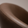 Era Chair in Major Brown faux leather with a rounded upholstered back, padded seat and slim black legs.