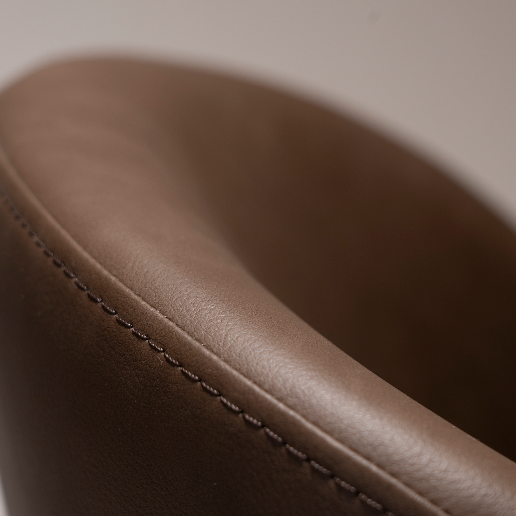 Era Chair in Major Brown faux leather with a rounded upholstered back, padded seat and slim black legs.