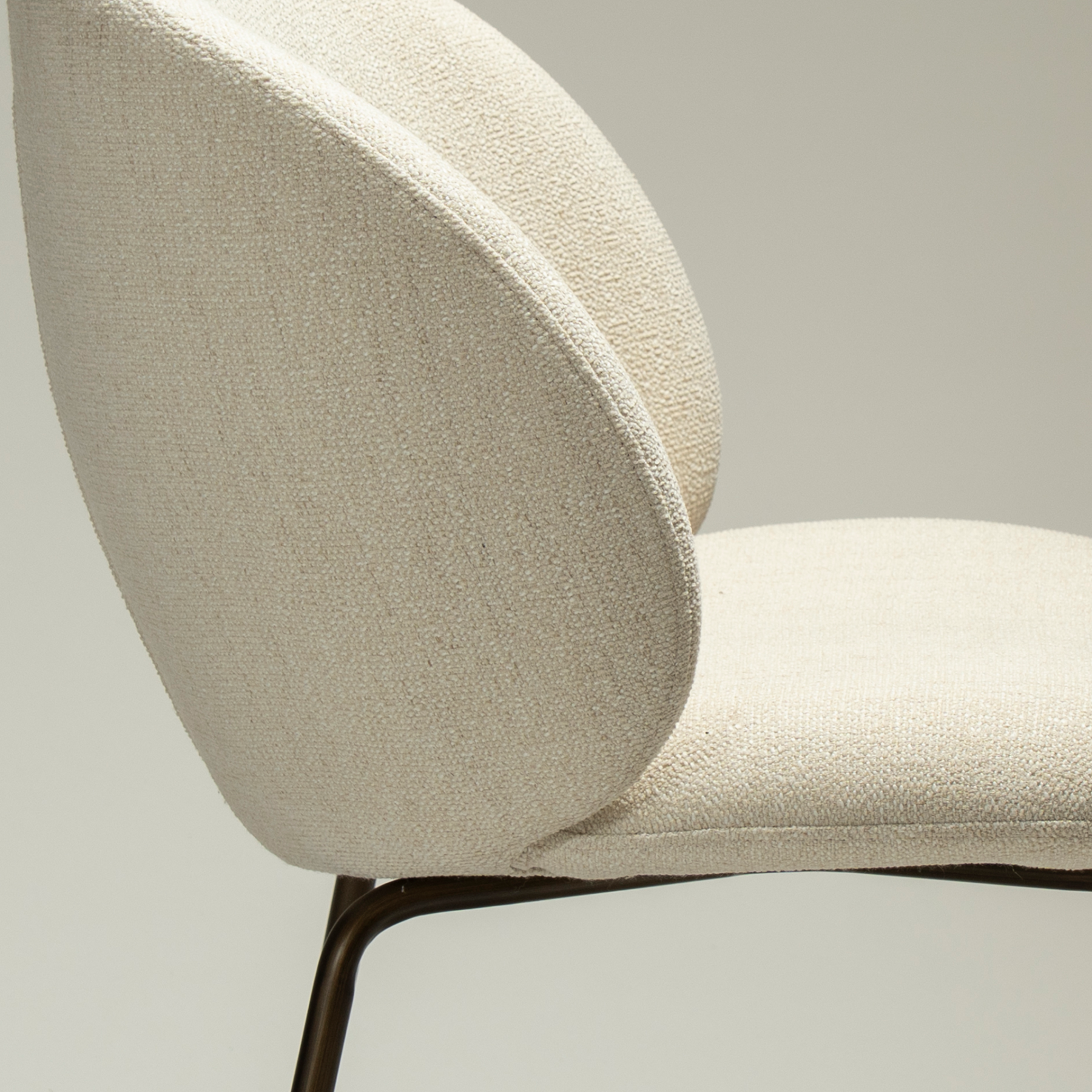 Era Chair in Simply Beige upholstery with rounded backrest, curved seat and slim Antique Brass legs.