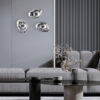 mabell-wall-light-lifestyle Mabell Wall Light with sculptural curved glass shade, reflective finish and exposed central bulb.