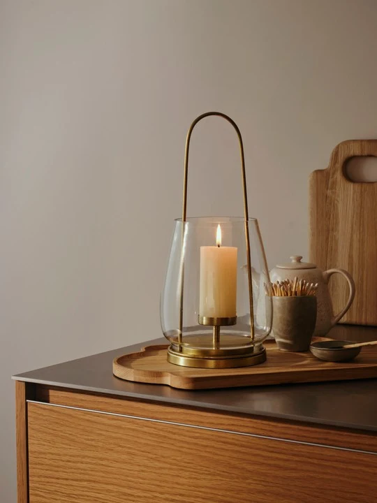 nilo-lantern-brass-metal-glass-lifestyle Nilo Lantern in brass-finish metal and clear glass with a tall contemporary design