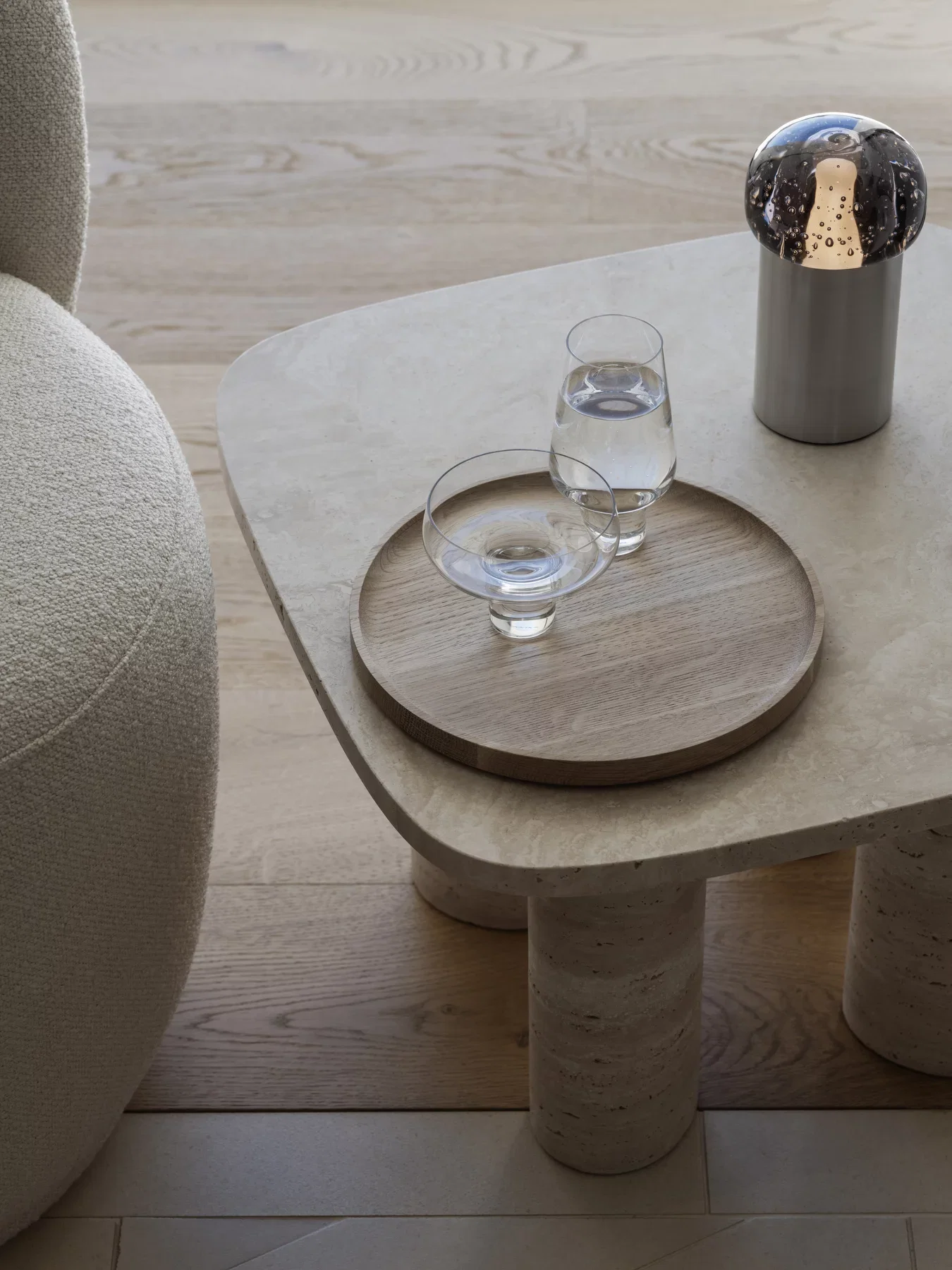 Koyoi Champagne Coupe in clear glass styled with coordinating glassware on a contemporary travertine coffee table