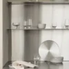 Koyoi Champagne Coupe in clear glass styled with coordinating glassware on contemporary stainless steel kitchen shelving