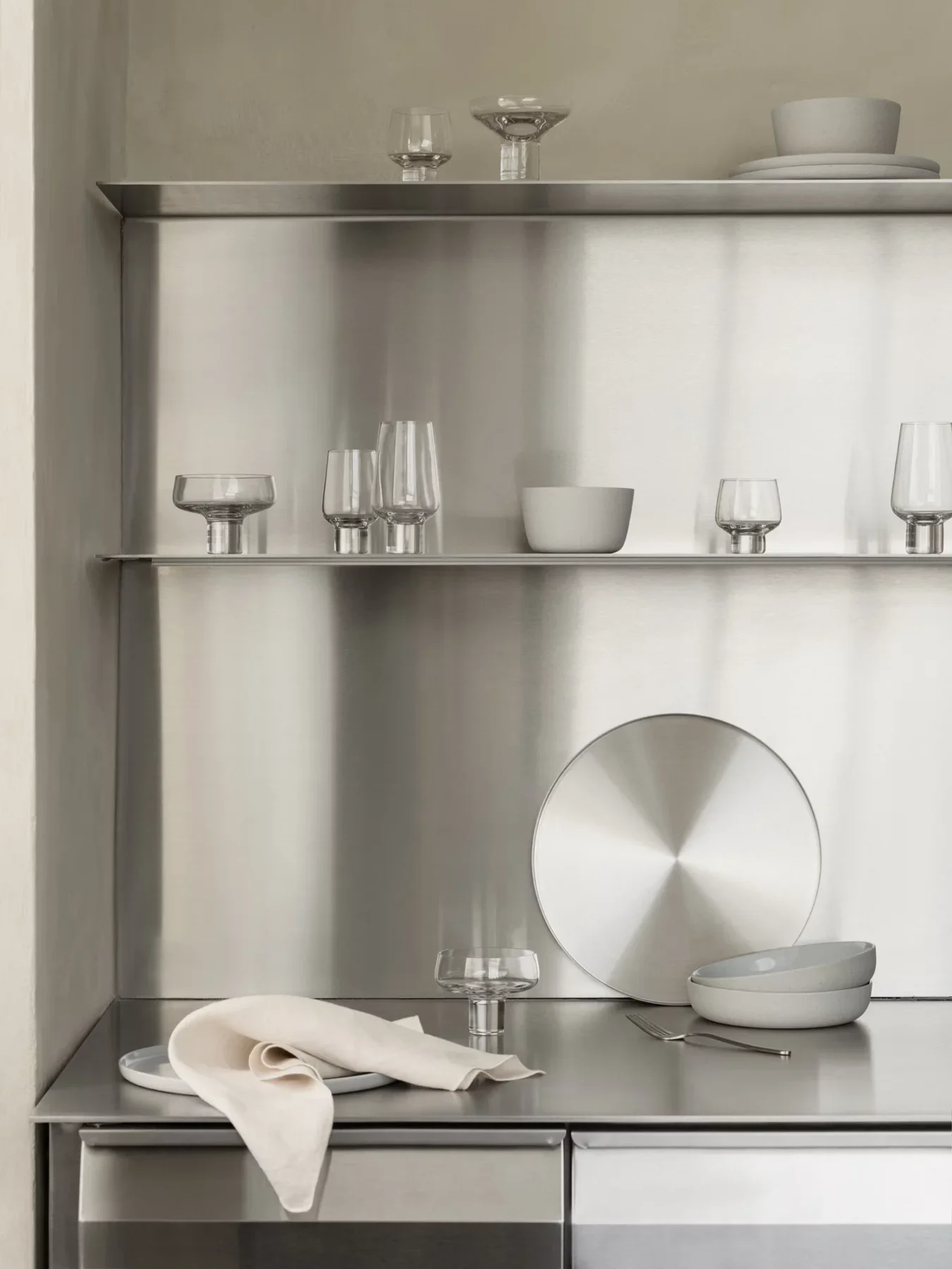 Koyoi Champagne Coupe in clear glass styled with coordinating glassware on contemporary stainless steel kitchen shelving