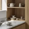 Koyoi Champagne Coupe in clear glass styled on oak kitchen shelving with neutral tableware