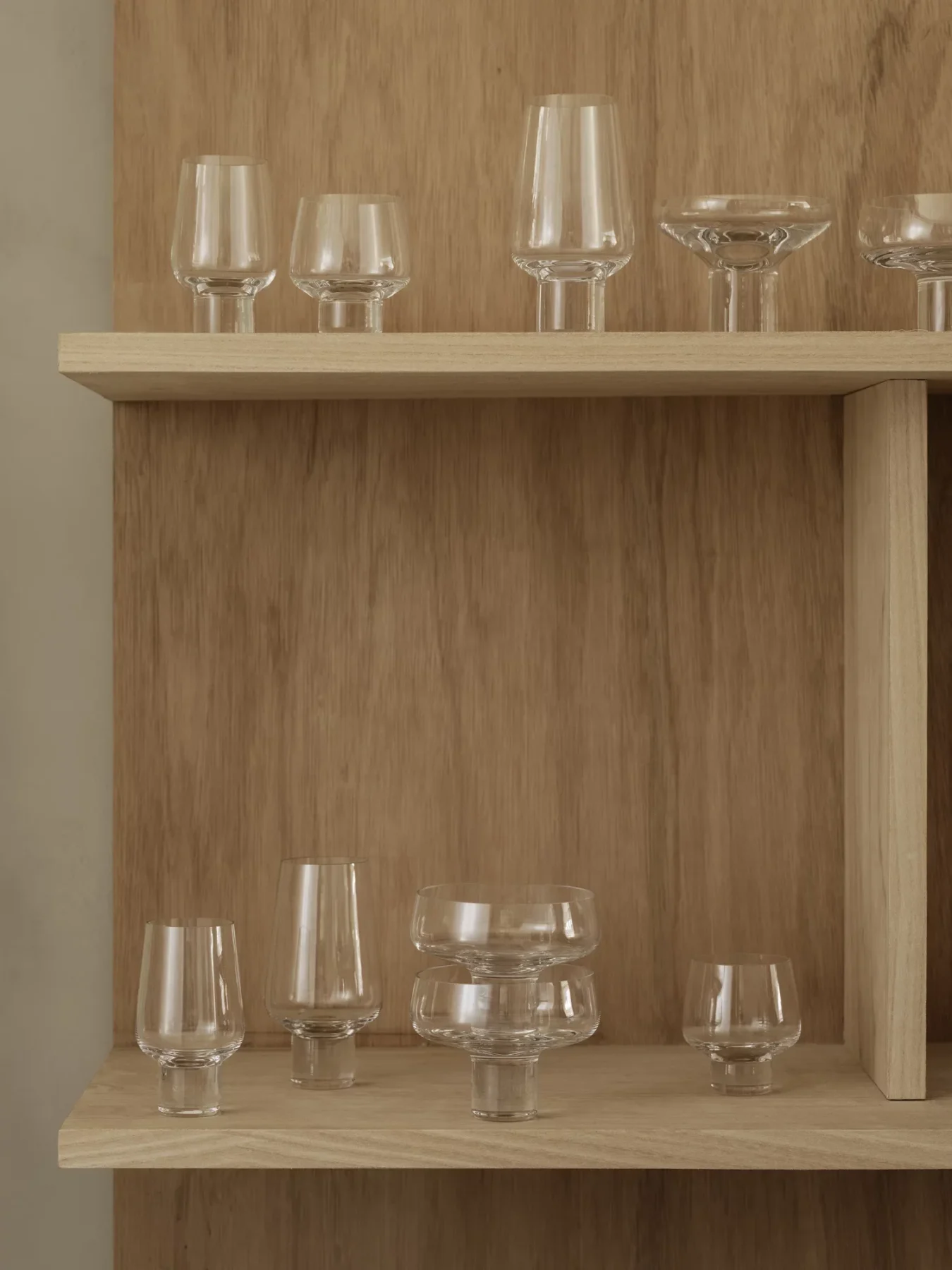 Koyoi clear glass Champagne Coupes displayed with coordinating mouth-blown glassware on oak shelving